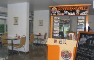 um restaurante com duas mesas e cadeiras e uma placa em The Blooms Residence em Banguecoque mais 15 fotografias