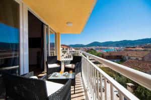 d'un balcon avec des chaises et une table offrant une vue. dans l'établissement Apartments Sunshine Home, à Vela Luka