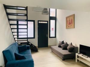 ein Wohnzimmer mit einem blauen Sofa und einer Treppe in der Unterkunft NUEVOS DUPLEX PRINCIPE VERGARA in Madrid