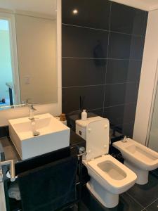 y baño con lavabo, aseo y espejo. en ARTOWER - Ocean View 1 bedroom apartment, en Punta del Este