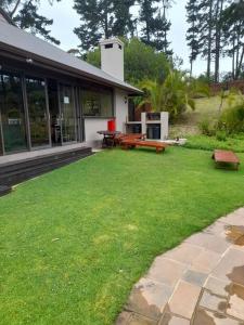 a house with a yard with benches and a patio at Pezula Holiday in Knysna
