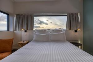 a bedroom with a large bed with a large window at PADJA Hôtel & Spa Vannes in Vannes