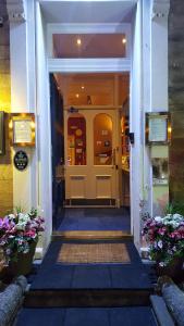 愛丁堡的住宿－多尼亞同樂會酒店，台阶上鲜花盛开的建筑的前门