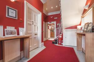 a hallway with red walls and a red carpet at Hotel Ceilidh-Donia in Edinburgh
