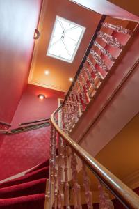 
a stairway leading up to a balcony with a clock on it at Hotel Ceilidh-Donia in Edinburgh
