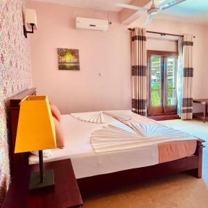 1 dormitorio con 1 cama con lámpara amarilla en Blinkbonnie Inn, en Kandy