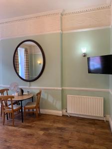 a dining room with a table and a mirror at Thanet Hotel in London