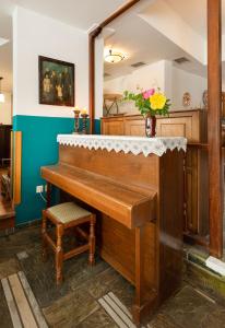 a piano in a room with a vase of flowers at Dimosthenis in Goumenissa