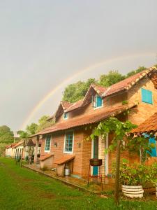 um arco-íris sobre uma fila de casas num quintal em Pousada Shangrilá São Thomé em São Thomé das Letras
