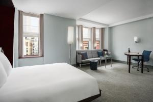 a hotel room with a white bed and a desk at Royalton New York in New York