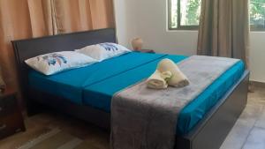 a bed with blue sheets and two towels on it at Riverside Mount Simpson Upper in Mahe
