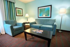 um quarto de hotel com duas cadeiras e uma mesa de centro em Holiday Inn Hotel & Suites Ocala Conference Center, an IHG Hotel em Ocala