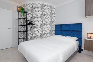 een slaapkamer met een wit bed en een blauwe en witte muur bij The City Nest - Duke Housing in Créteil