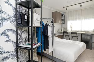 a bedroom with a bed and a kitchen at The City Nest - Duke Housing in Créteil