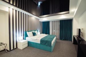 a bedroom with a blue bed and a television at Royal Plaza Hotel in Tbilisi City