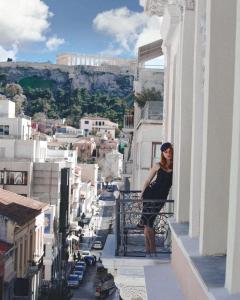 
a woman standing on a ledge in front of a building at Emporikon Athens Hotel in Athens
