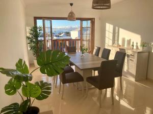 Un comedor con mesa y sillas y un balcón. en Luxury 4-Bedroom Villa With Heated Pool + Sea View, en Playa Blanca