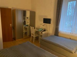 a bedroom with a bed and a desk at Pension Pagalies in Düsseldorf