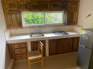 una pequeña cocina con fregadero y ventana en Mi refugio, en Almirante