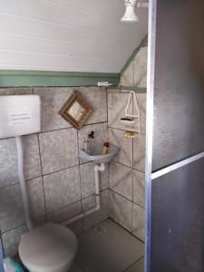 ein kleines Badezimmer mit Toilette und Waschbecken in der Unterkunft CASA PRAIA BEIRA MAR COM PISCINA 5 QUARTOS ACOMODA 12 pessoas in Imbé + 26 Fotos