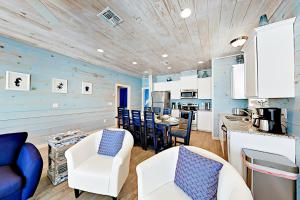 a kitchen and living room with blue walls and white furniture at Coral Cove in Port Aransas