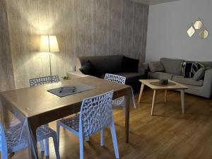 - un salon avec une table et un canapé dans l'établissement Au 96 - 4 pers - Aux portes de Lille - 3 min Métro Lomme Lambersart, à Lambersart