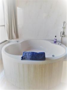 a white bath tub with a blue towel in it at Panorama Bay View 3 room in Haifa