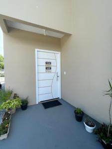 un edificio blanco con una puerta con un cartel. en Jardim da Vovó!, en Florianópolis