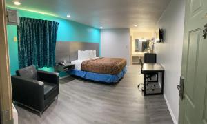 una camera da letto con un letto, una scrivania e una sedia di Country Hill Inn & Suite Eagle Pass a Eagle Pass