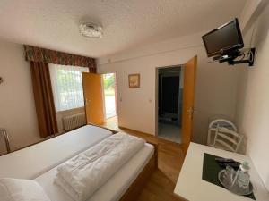 a bedroom with a bed and a tv on the wall at Ferien- & Monteurzimmer Markhausen in Friesoythe