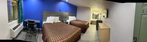 Habitación de hotel con 2 camas y pared azul en Country Hill Inn & Suite Eagle Pass, en Eagle Pass