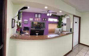 un ufficio con un bancone con una parete viola di Country Hill Inn & Suite Eagle Pass a Eagle Pass