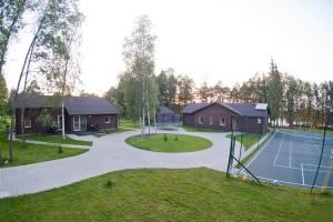 a tennis court next to a house with a tennis at Spalio krantas in Giedraičiai