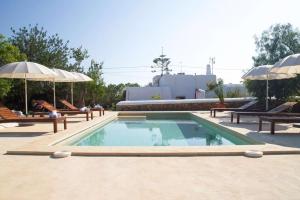 einen Pool mit 2 Stühlen und Sonnenschirmen in der Unterkunft FINCA RELAX IBIZA STILE in San Jose de sa Talaia