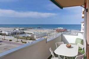 a balcony with a table and chairs and a view of the ocean at CRIMA LEDA LUXURY in Misano Adriatico