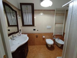 bagno con lavandino, servizi igienici e specchio di Casa Vacanza Da Nonna Pippi a Copertino
