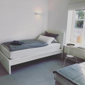 ein weißes Bett in einem Zimmer mit Fenster in der Unterkunft Ferienwohnung Hof Flüh in Klenzau