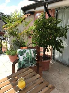 - un banc en bois avec un oreiller sur la terrasse dans l'établissement Appartamento con terrazza e posto auto Libri e Giardini, à Pero