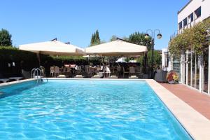 a swimming pool with umbrellas and a hotel at Hotel Cristallo Relais, Sure Hotel Collection By Best Western in Tivoli
