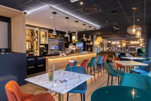 restauracja ze stołami i krzesłami oraz bar w obiekcie PADJA Hôtel & Spa Vannes w mieście Vannes