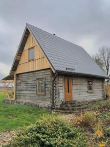 una pequeña casa de madera con techo negro en Rīga Mangalsala Cottage with sauna, en Riga