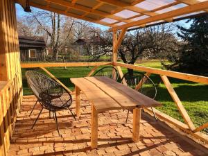 a wooden bench and two chairs on a patio at Rīga Mangalsala Cottage with sauna in Riga