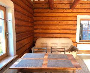 ein Zimmer mit einem Tisch und einem Sofa in einer Hütte in der Unterkunft Rīga Mangalsala Cottage with sauna in Riga