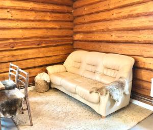 a white couch in a room with a wooden wall at Rīga Mangalsala Cottage with sauna in Rīga