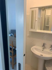 een badkamer met een wastafel en een kast bij Là Mì Cà in La Spezia +18 foto's