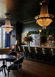 a bar with chairs and tables and chandeliers at Marine North Berwick in North Berwick
