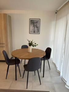 a dining room with a wooden table and chairs at Les jardins du Soleil in Gorbio