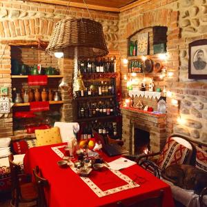 a dining room with a red table and a fireplace at Dzveli Galavani -Old Wall in Tʼelavi
