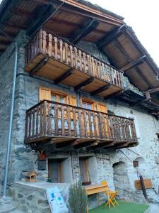 a building with a wooden balcony on the side of it at CASA VACANZE NORA in Chamois