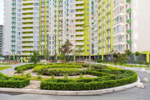 a garden in the middle of a city with tall buildings at MYFREEDOM Апартаменти метро Нивки in Kyiv